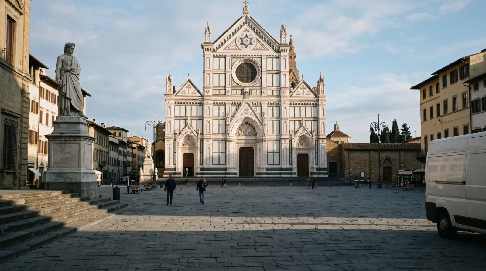 Polychrome marble façade of the Basilica of Santa Croce Florence across the piazza in early morning light