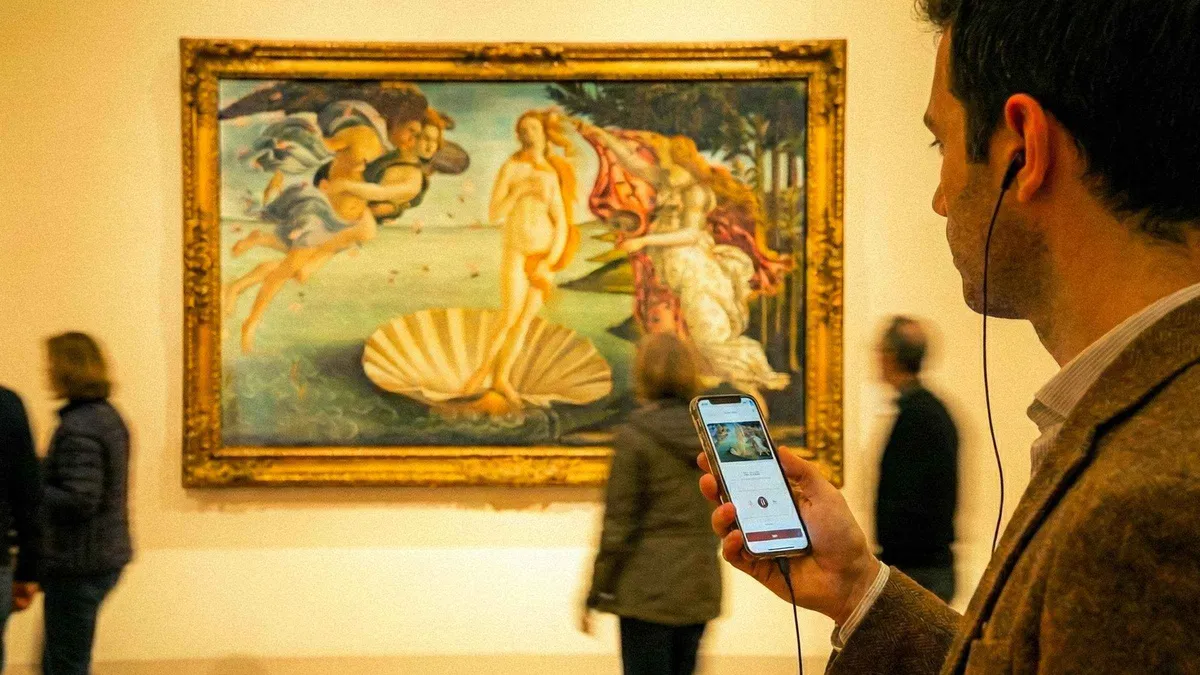 Reserved-entry visitor with an audioguide app inside the Uffizi Gallery in Florence, Italy