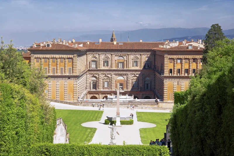 The rusticated stone facade of Palazzo Pitti above its sloping piazza, entry point for Pitti Palace and Boboli Gardens tickets in Florence, Italy
