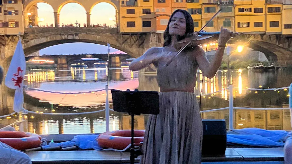 Electric boat with a live violinist on an Arno River cruise in Florence