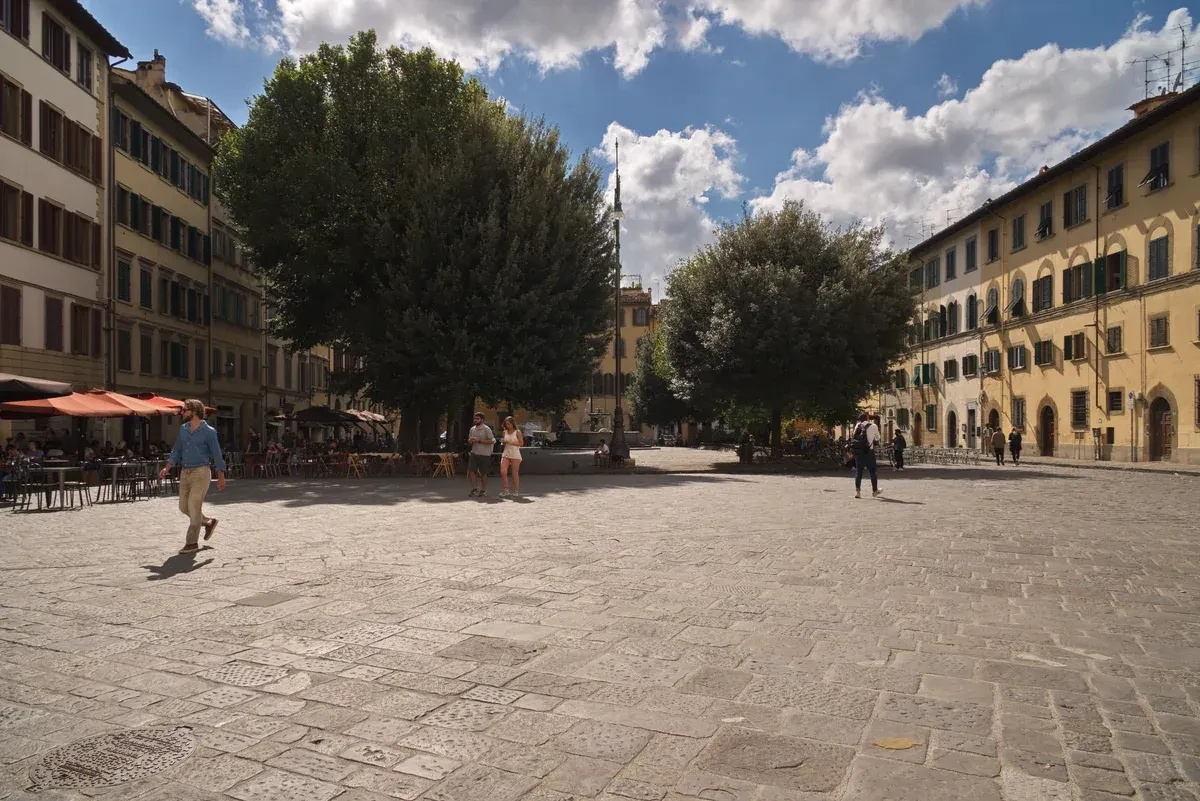 Piazza Santo Spirito seen from the basilica, café tables along the edge of the square where outdoor drinking stops at midnight, part of the bars in Florence, Italy rules