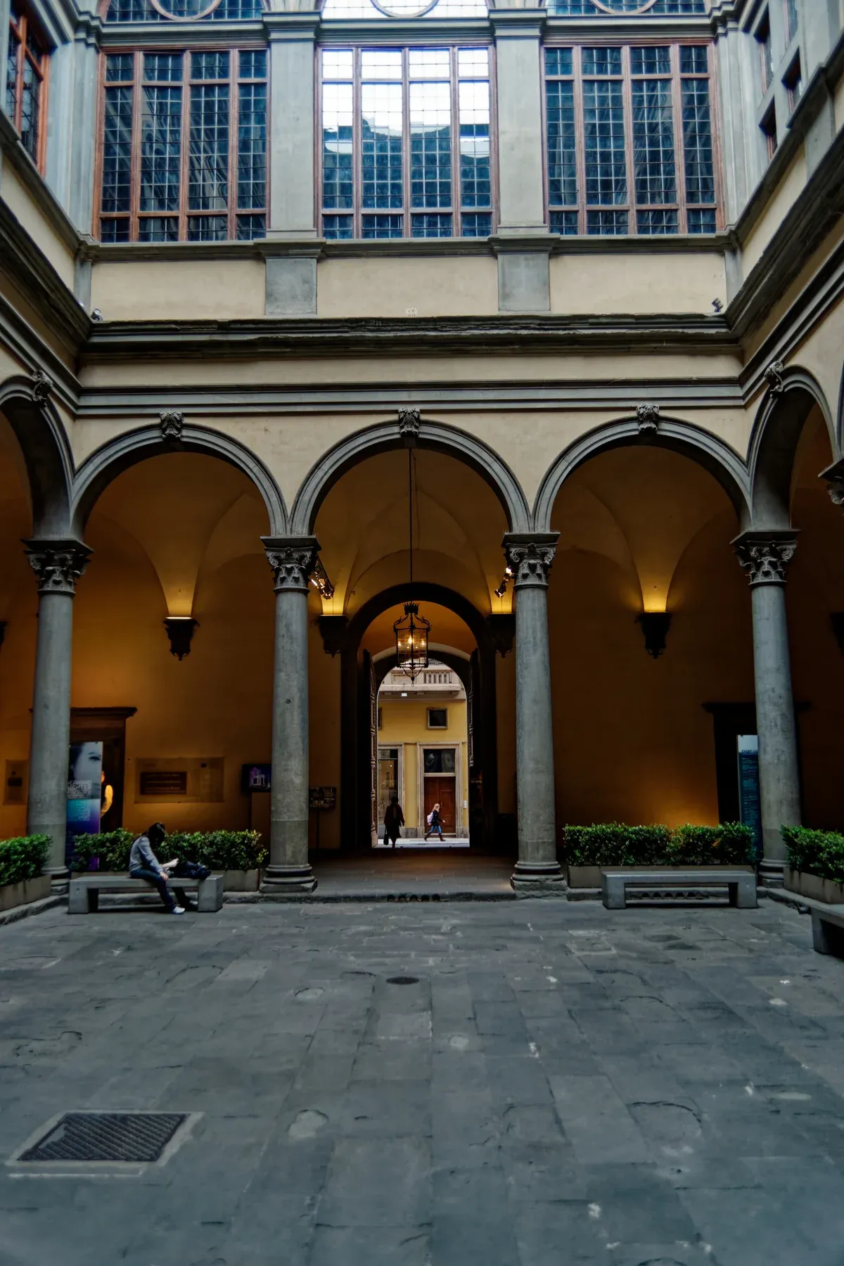 The colonnaded Renaissance courtyard of Palazzo Strozzi in Florence, with the street door seen through the far arch