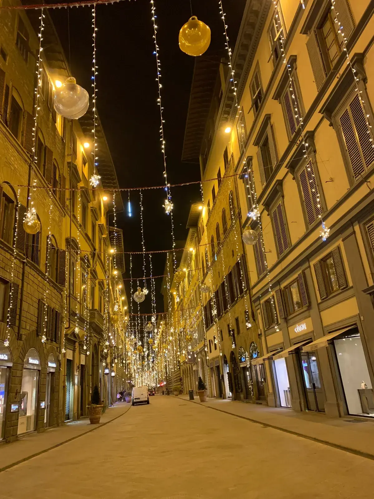Via Tornabuoni in the evening, lit shop windows under strings of lights, the designer street for shopping in Florence, Italy